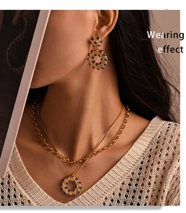 Detail von Vintage Goldkette und blauen Strassohrringen, getragen von Model