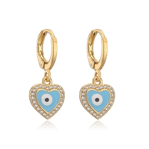 Macro view of gold heart earrings with blue enamel evil eye and sparkling crystals