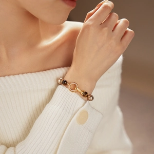 Detailed macro of vintage gold-plated bead bracelet with tiger eye stone and diamond buckle