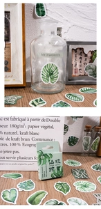 Detail of green forest stickers on stationery and glass bottle for scrapbooking