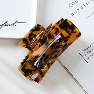 Detailed close-up of a 10cm acetate tortoiseshell hair claw clip with hollow design