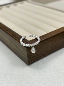 Close-up of S925 silver hollow heart ring with a white freshwater pearl tassel charm