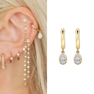 Close-up of gold pear cut cubic zirconia drop earrings with model wearing style