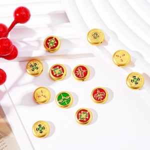 Flat lay of gold flat round beads with red and green enamel knots on white background