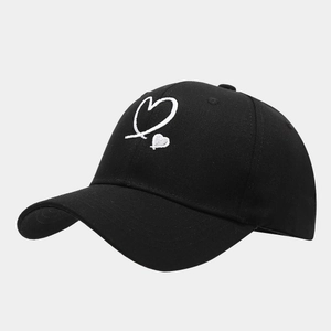 Detail of double heart embroidery and twill fabric texture on a black baseball cap