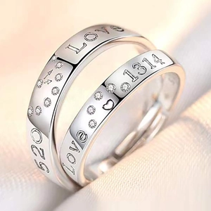 Close-up of silver adjustable couple rings with LOVE 520 engravings and heart detail