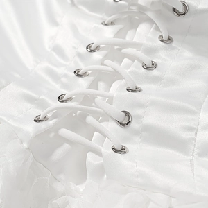 Detail of white satin dress featuring cross-tie lacing with metal eyelets and lace trim