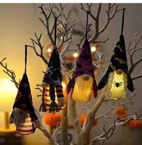 Macro de quatre gnomes d'Halloween lumineux avec LED suspendus sur des branches blanches