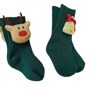 Cute green Christmas baby socks featuring 3D reindeer decor and bells on white background