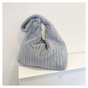 Close-up of fluffy striped plush tote bag in hazy blue with soft faux fur texture