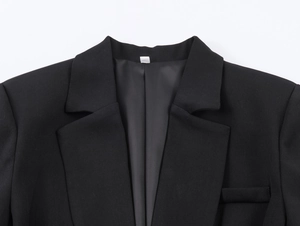Detail shot of black blazer notch lapel and fabric texture with white inner neck label