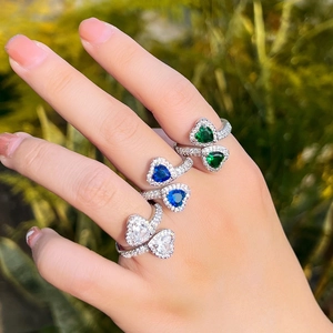 Detailed view of silver open heart rings with blue and green sapphire zirconia settings
