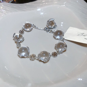 Detail of snowflake bead bracelet with clear crystal beads on white ceramic background