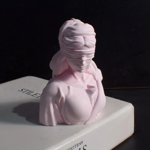 Pink Justice Goddess bust sculpture placed on decorative books with dramatic lighting
