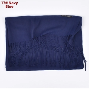 Detailed close-up of navy blue cashmere scarf with elegant tassels and brand label