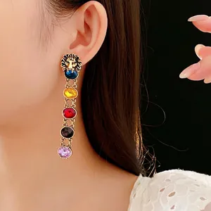 Vintage lion head gold earrings with colorful crystal tassels on a model for luxury look
