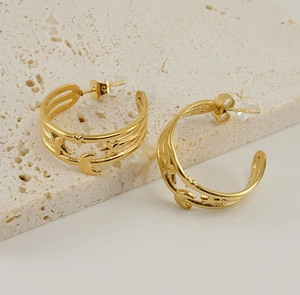 Detail of 18K gold star and moon earrings on stone surface showing butterfly backings