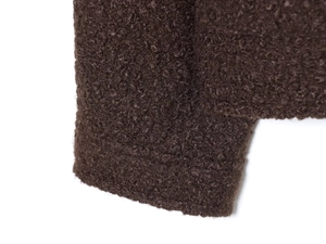 Détail du tissu en peau lainée marron foncé montrant la texture épaisse aux poignets