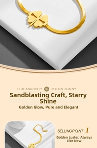 Detail of gold clover bracelet with sandblasted texture and flat herringbone chain