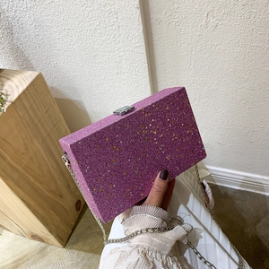 Purple glitter box clutch with colorful star patterns and a silver chain strap