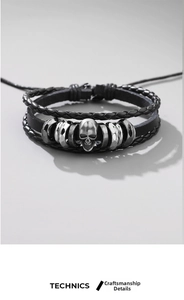 Detail view of woven leather layers and vintage silver skull charm on punk bracelet