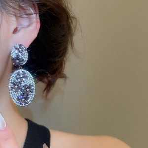 Macro close-up of vintage oval silver earrings with purple crystals and sparkling zircons