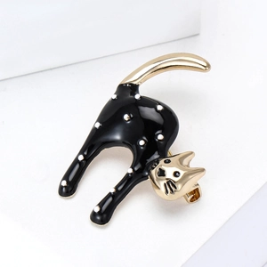 Cute black and white polka dot cat brooch with gold alloy finish on a white stand