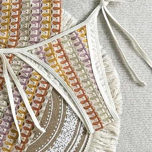 Gros plan sur un maillot de bain crochet bohème coloré avec motifs de feuilles et liens blancs