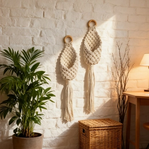 Set of two handmade macrame hanging baskets with wooden rings and tassels on white wall