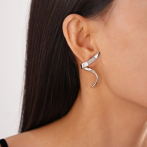 Close-up of minimalist silver irregular geometric ear cuff showing smooth metallic finish