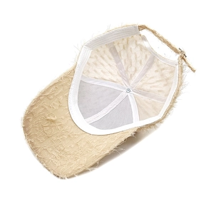 Detail showing inner mesh lining and adjustable buckle of beige distressed baseball cap