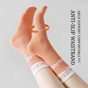 Orange mid-calf yoga socks with silicone anti-slip grips and Keep Alive text
