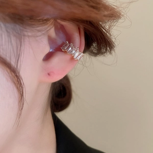 Close-up of gold-plated ear cuff featuring five rectangular zircons in a minimalist style
