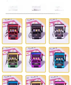 Close-up of mini slot machine keychains in various metallic colors with lucky slot lever