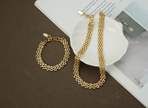 Detailed view of golden woven chain necklace and bracelet set with lobster clasp