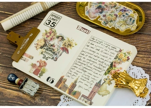 Vintage scrapbooking stickers with floral and retro motifs on a wooden table with accessories