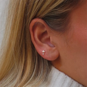 Detail of s925 silver leaf stud earring with crystal drop worn on female ear lobe