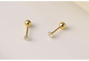 Close-up of golden 925 silver stud earrings with round zircon and screw back closure