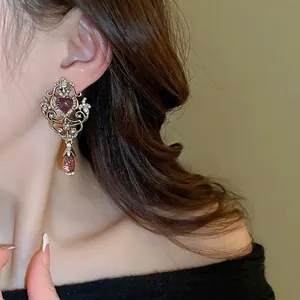 Vintage palace style earrings with purple heart and water drop gems on model
