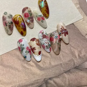 Detailed view of vintage French style nail art set with roses, amber textures and pearls