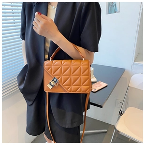 Sac à bandoulière matelassé marron sur modèle montrant la taille et la chaîne dorée