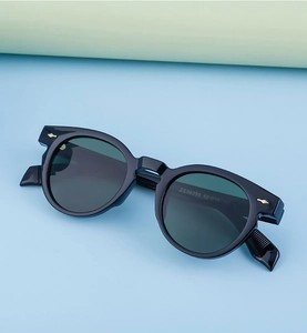 Detail of black oval sunglasses showing golden arrow hinge and ZS98099 model engraving