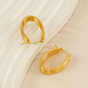Detail of gold-plated triple-layer oval hoop earrings featuring a hinge closure design