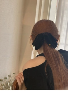 Detailansicht einer großen schwarzen Samtschleife mit Goldakzenten an einem Modell