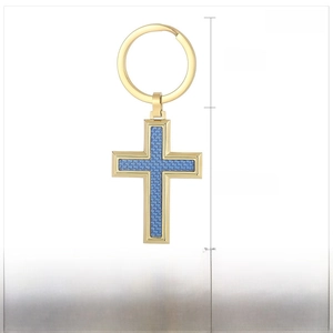 Detail view of gold stainless steel cross keychain with blue carbon fiber resin texture