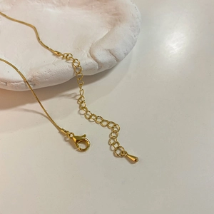 Détail du collier plaqué or avec fermoir mousqueton et sa chaîne d'extension réglable