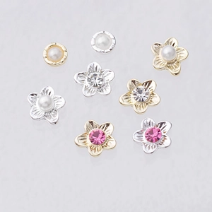 Macro shot of 5-petal flower nail charms with rhinestones and pearls for DIY art
