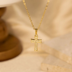 Golden cross pendant necklace with white zircon stones on a thin link chain