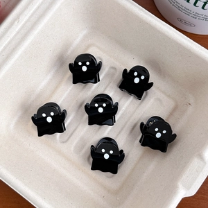 Close-up of six ghost-shaped mini hair clips on a tray for Halloween styling