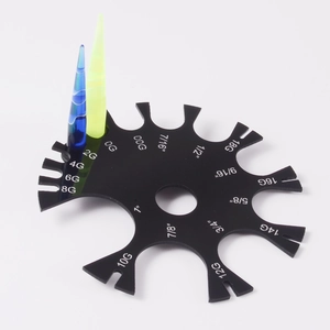 Macro detail of black acrylic body piercing gauge with blue and green tapers on white